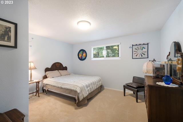 bedroom with light carpet and a textured ceiling