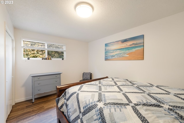 bedroom featuring a textured ceiling and dark wood-type flooring