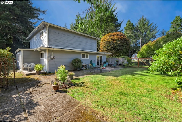 back of house featuring a lawn and a patio area