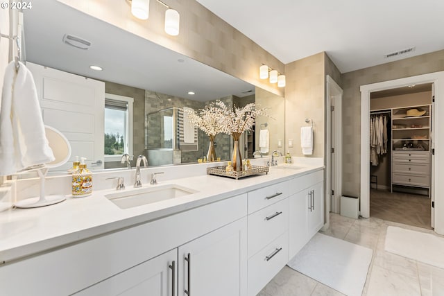 full bath with a walk in closet, marble finish floor, visible vents, and a sink