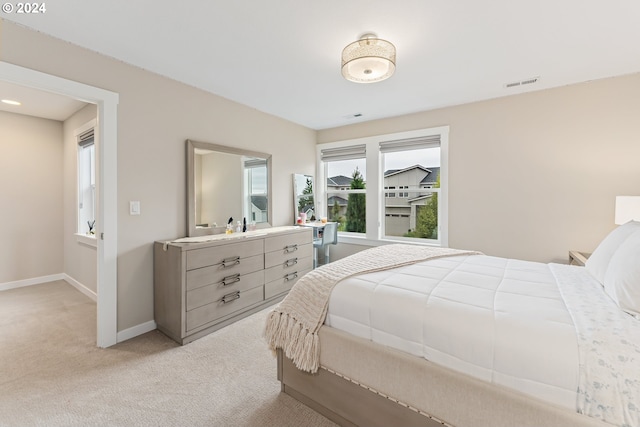 bedroom featuring light carpet, visible vents, and baseboards