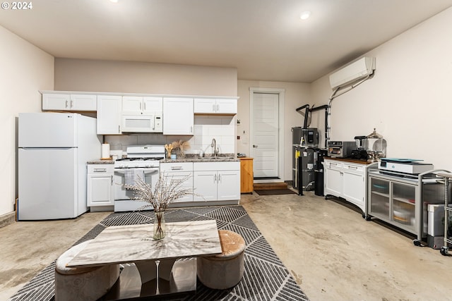 kitchen featuring white appliances, concrete floors, a sink, white cabinetry, and an AC wall unit