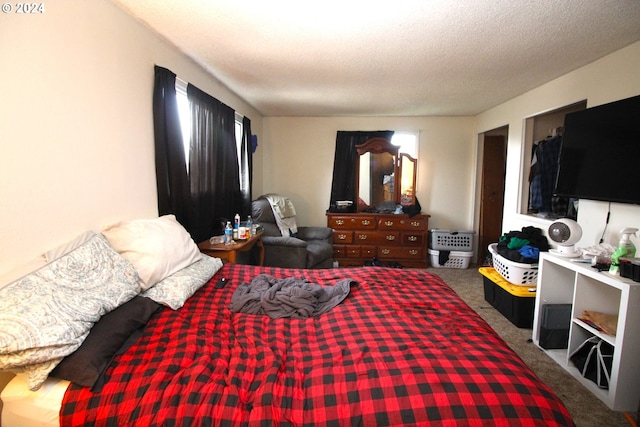 bedroom featuring dark colored carpet and a textured ceiling