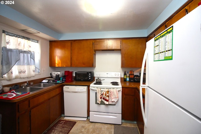 kitchen featuring white appliances, sink, and light tile floors