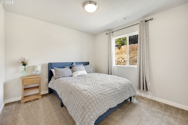 carpeted bedroom with a textured ceiling