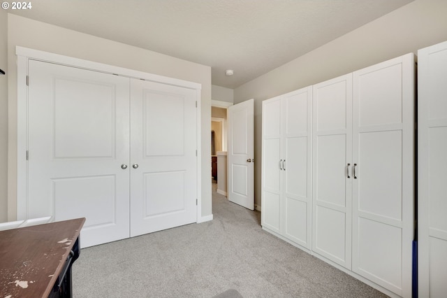 unfurnished bedroom with a closet and light colored carpet