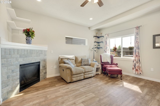 living room with ceiling fan, light hardwood / wood-style floors, and a fireplace