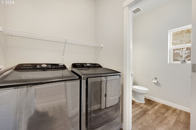 laundry area featuring washer and clothes dryer and light wood-type flooring