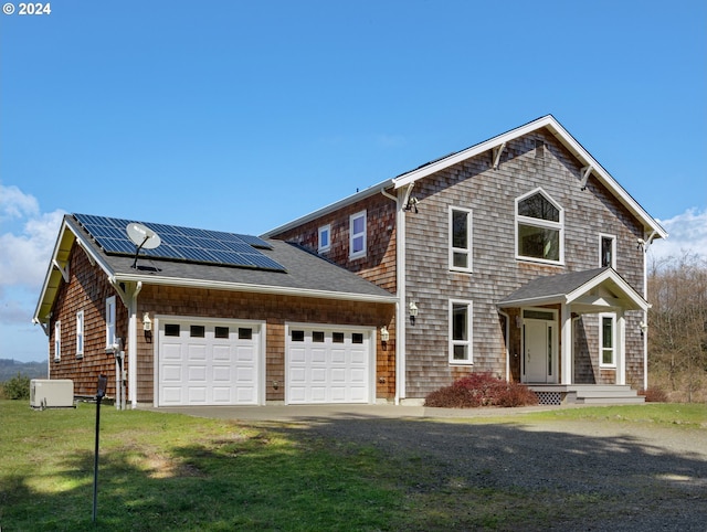 view of front of house featuring solar panels, a garage, and a front yard