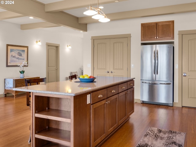 kitchen with a center island, hanging light fixtures, beamed ceiling, dark hardwood / wood-style flooring, and stainless steel fridge