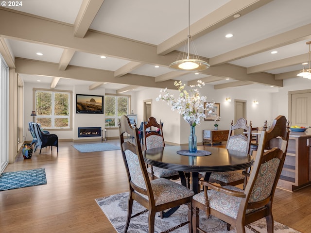 dining room with beamed ceiling and light hardwood / wood-style flooring