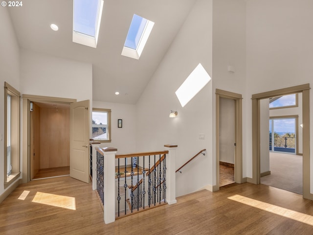 32227 Seascape Ln, Cannon Beach, OR 97110 - corridor featuring high vaulted ceiling, a skylight, an upstairs landing, and light wood-type flooring