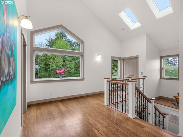 32227 Seascape Ln, Cannon Beach, OR 97110 - unfurnished room featuring a skylight, wood finished floors, high vaulted ceiling, and baseboards