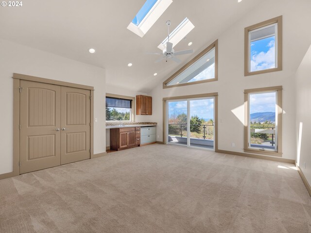 32227 Seascape Ln, Cannon Beach, OR 97110 - unfurnished living room with high vaulted ceiling, light carpet, a skylight, recessed lighting, and baseboards