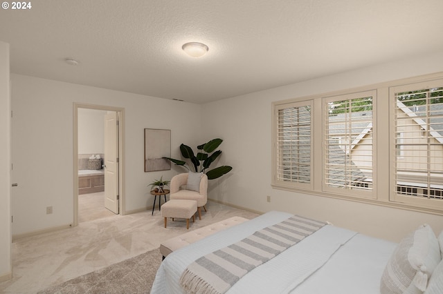 bedroom with light colored carpet, connected bathroom, and a textured ceiling