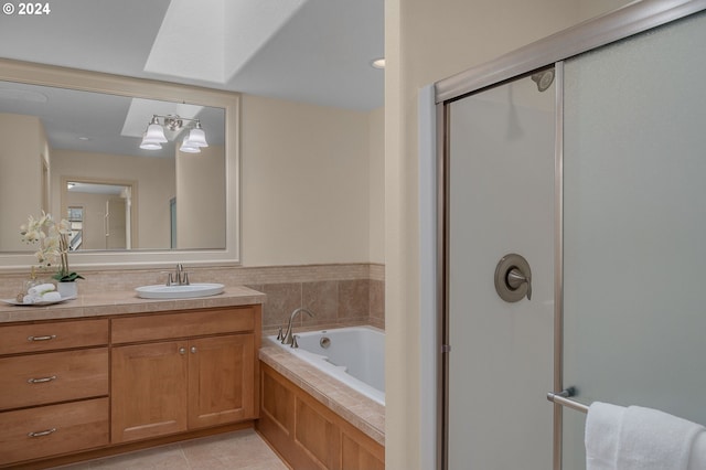 bathroom with a skylight, vanity, plus walk in shower, and tile patterned flooring