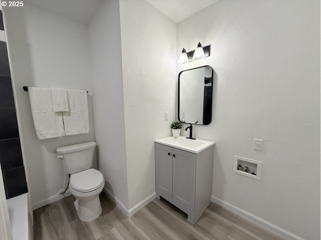 bathroom with hardwood / wood-style flooring, vanity, and toilet