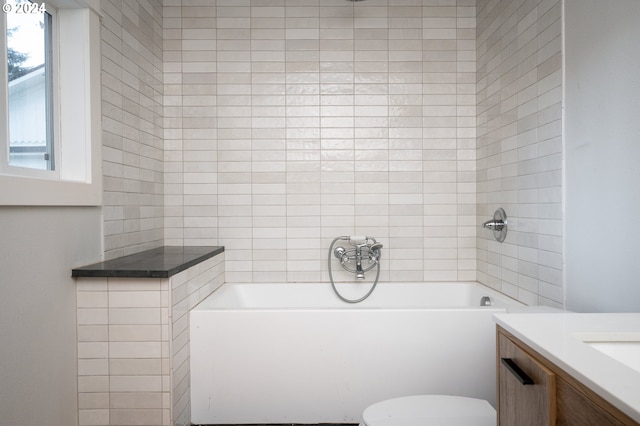 bathroom with toilet, vanity, and a tub