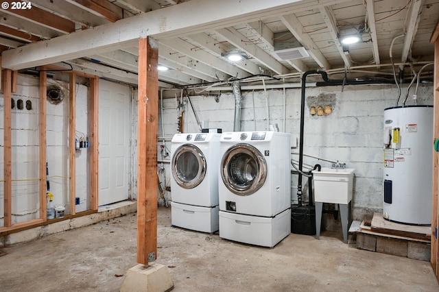 clothes washing area with water heater, sink, and washing machine and clothes dryer