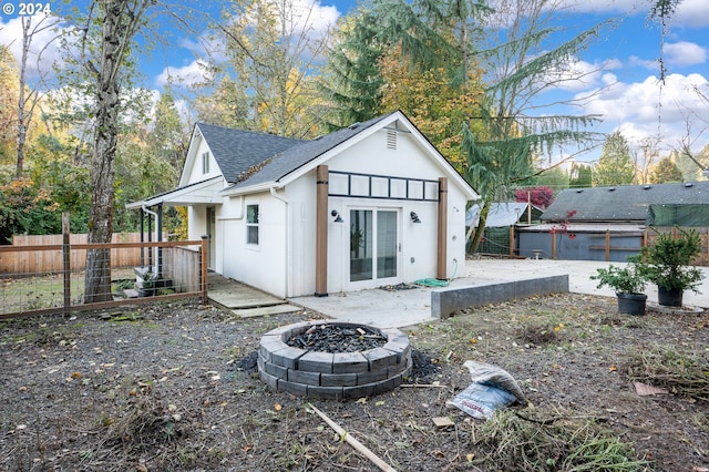 rear view of property with a patio, an outdoor fire pit, and a swimming pool