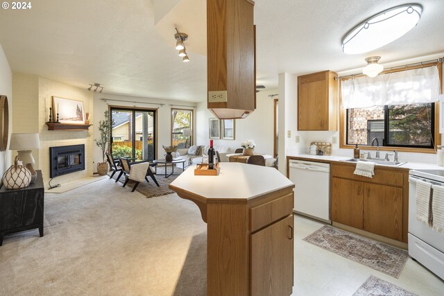 16354 SW 130th Ter Unit 76, King City, OR 97224 - kitchen with white dishwasher, light countertops, a sink, electric stove, and open floor plan