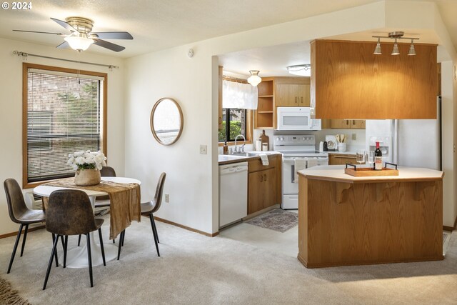 16354 SW 130th Ter Unit 76, King City, OR 97224 - kitchen featuring a sink, white appliances, baseboards, light countertops, and a ceiling fan