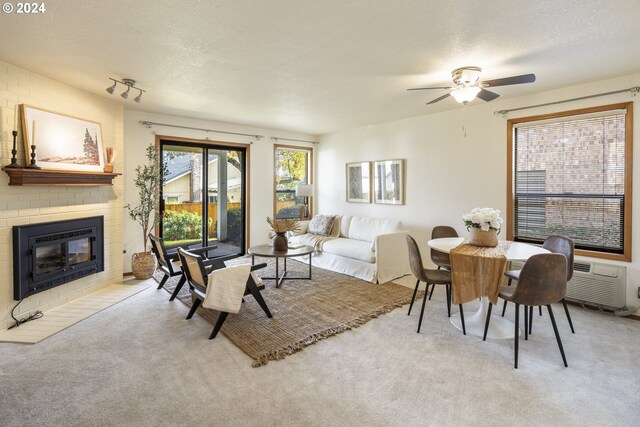 16354 SW 130th Ter Unit 76, King City, OR 97224 - living area featuring carpet floors, ceiling fan, a fireplace, and a textured ceiling