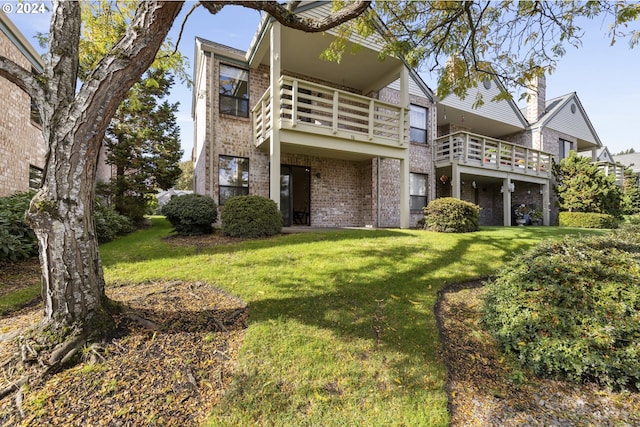 16354 SW 130th Ter Unit 76, King City, OR 97224 - view of front of home with brick siding, a balcony, and a front lawn