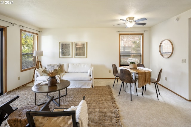 living room featuring light carpet, a healthy amount of sunlight, and ceiling fan