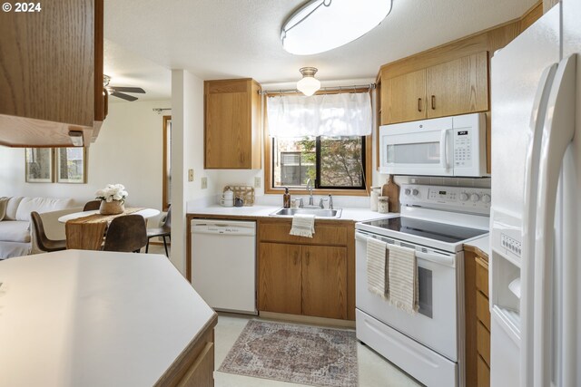 16354 SW 130th Ter Unit 76, King City, OR 97224 - kitchen featuring white appliances, ceiling fan, light countertops, brown cabinets, and a sink