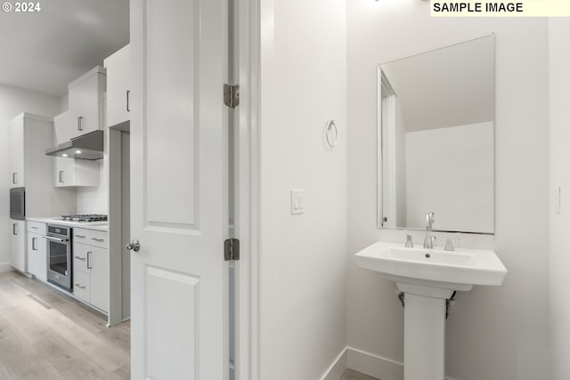 bathroom with backsplash and hardwood / wood-style flooring