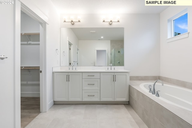 bathroom with vanity and tiled tub