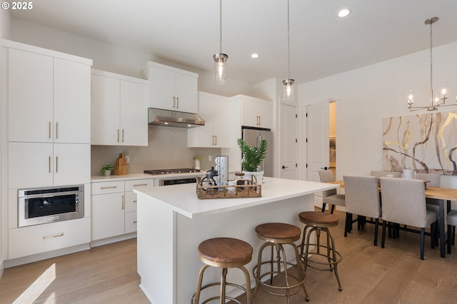 15708 NW Raywood Ln Unit L 24, Portland, OR 97229 - kitchen with under cabinet range hood, appliances with stainless steel finishes, recessed lighting, backsplash, and light wood-type flooring