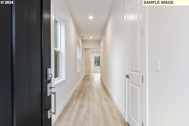 hallway with light hardwood / wood-style floors