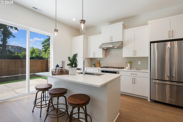 15708 NW Raywood Ln Unit L 24, Portland, OR 97229 - kitchen featuring stainless steel appliances, a sink, under cabinet range hood, tasteful backsplash, and recessed lighting
