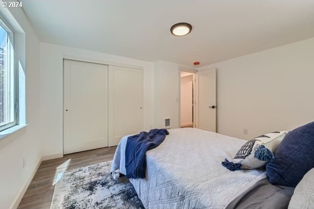 bedroom featuring wood-type flooring and a closet