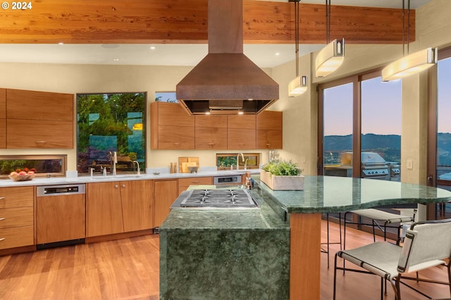 kitchen featuring appliances with stainless steel finishes, a mountain view, island range hood, decorative light fixtures, and beamed ceiling