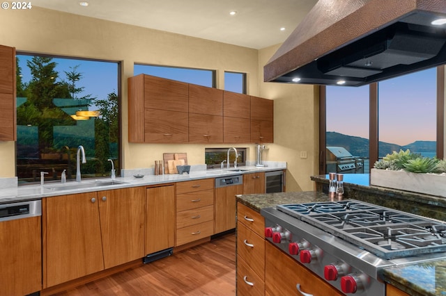 kitchen featuring sink, beverage cooler, island range hood, appliances with stainless steel finishes, and light wood-type flooring