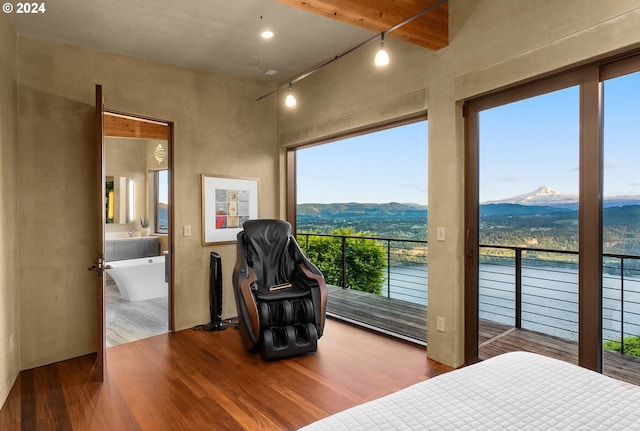 bedroom with a mountain view, hardwood / wood-style flooring, and ensuite bath