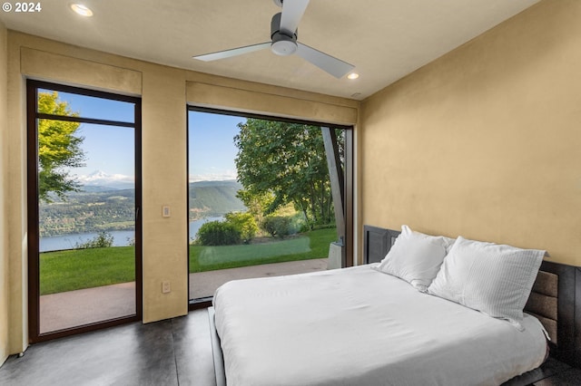 bedroom with ceiling fan and a water and mountain view