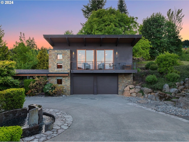 contemporary home with a garage and a balcony