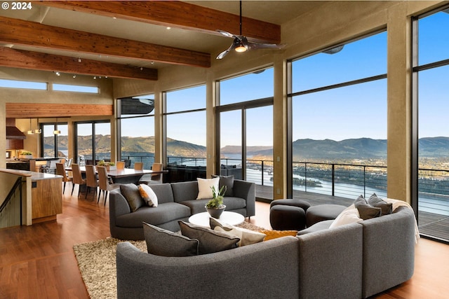 living room featuring beamed ceiling, plenty of natural light, and a water and mountain view