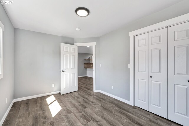 unfurnished bedroom featuring a closet and dark hardwood / wood-style floors