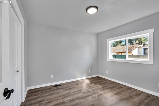 spare room featuring dark wood-type flooring