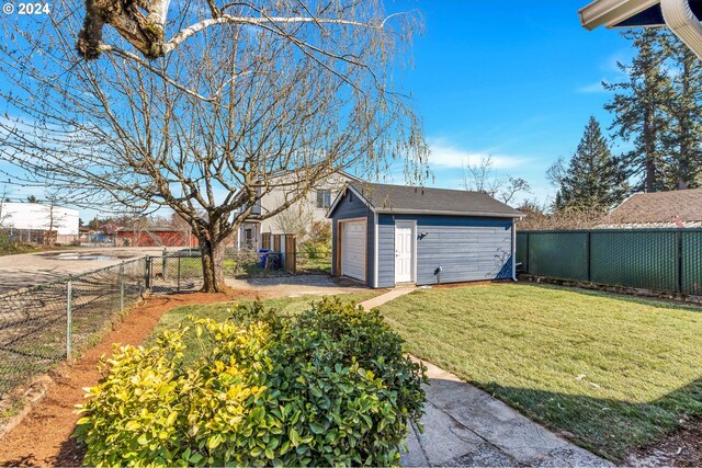 ranch-style home with a front yard, an outdoor structure, and a garage