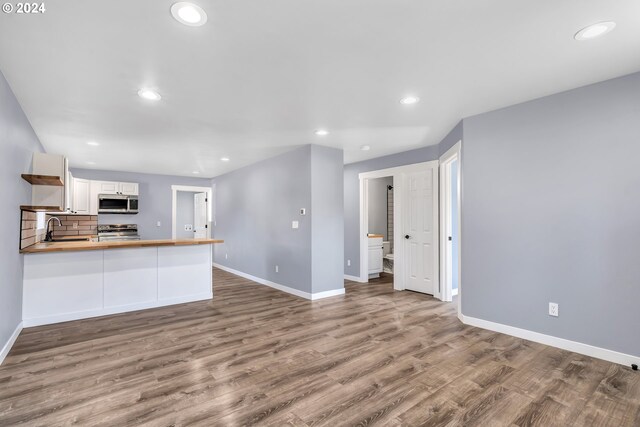 kitchen with sink, stainless steel appliances, backsplash, and hardwood / wood-style floors