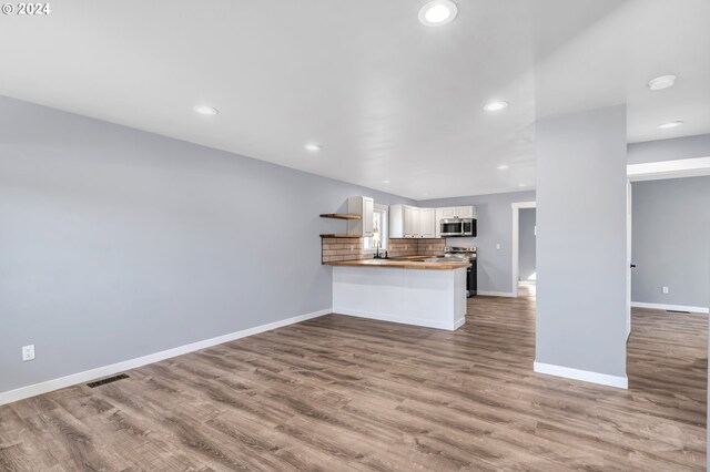 unfurnished living room with hardwood / wood-style floors and sink