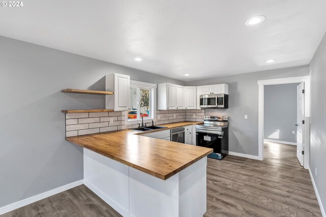 kitchen with butcher block countertops, range with electric cooktop, light hardwood / wood-style floors, and white cabinets