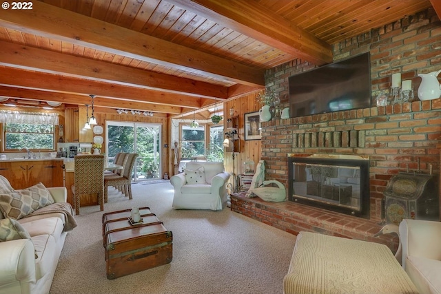 living room featuring a fireplace, wood walls, beamed ceiling, wooden ceiling, and carpet