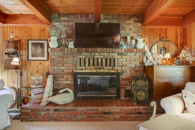 carpeted living room featuring wood walls, beamed ceiling, wooden ceiling, and a fireplace